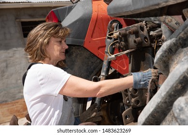 Woman Repairing A Tractor On Her Farm