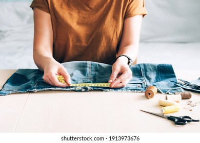 Woman repairs sews reuses fabric from old denim clothes economical reuse - Shutterstock ID 1913973676