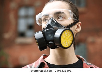 Woman in respirator and protective glasses outdoors - Powered by Shutterstock