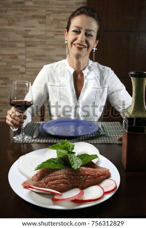 Woman in restaurant eating raw quibe