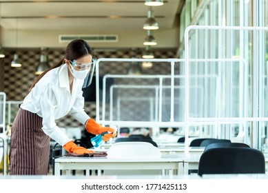 Woman Restaurant Staff Cleaning Table With Alcohol Spray Wearing Glove, Face Shield And Mask Before Open The Restaurant