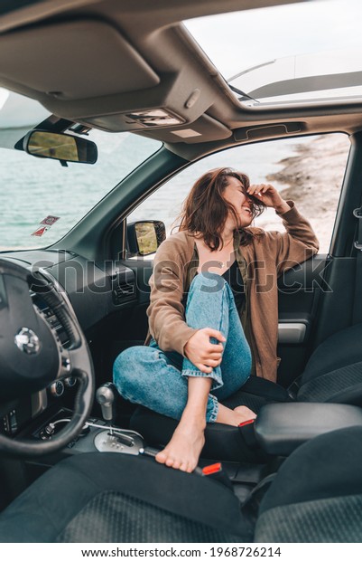 woman\
resting in car parked at sea beach. summer\
vacation