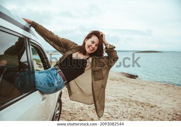 woman\
resting in car parked at sea beach. summer\
vacation