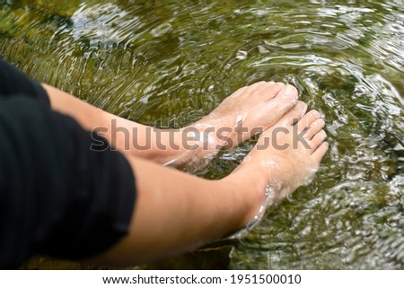 woman resting with feets in river water , concept relax time
