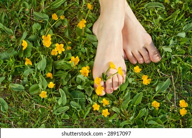 Woman resting her feet in the fresh spring vegetation under sunshine