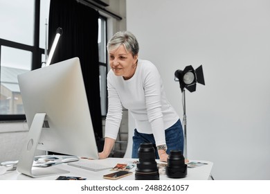 A woman reviews photographs on a computer screen in a photo studio. - Powered by Shutterstock