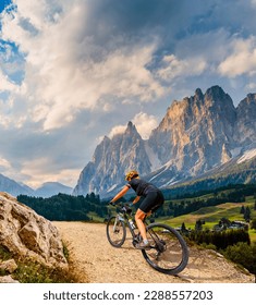 Woman ride electric mountain bikes in the Dolomites in Italy. Mountain biking adventure on beautiful mountain trails.