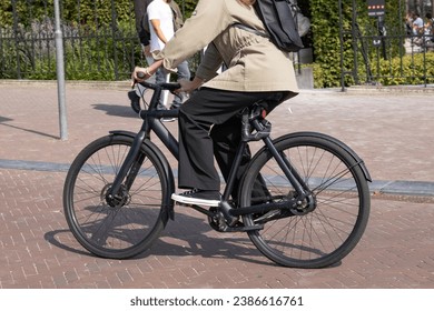 woman rides black e-bike in Amsterdam