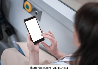 a woman rides a bus holding a mobile phone with a blank white screen in her hand. Gadget with blank free space for mockup. - Powered by Shutterstock