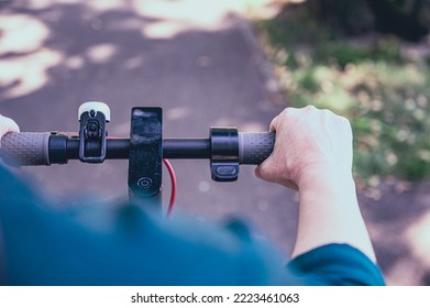 A Woman Rides An Electric Scooter In A City Park In Summer Outdoors, First Person View.