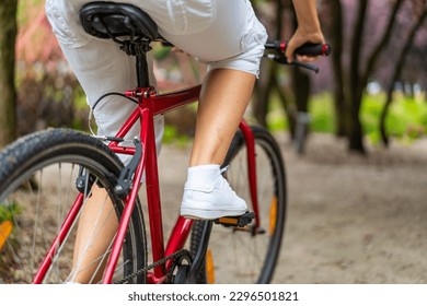 Woman riding bicycle in city park 