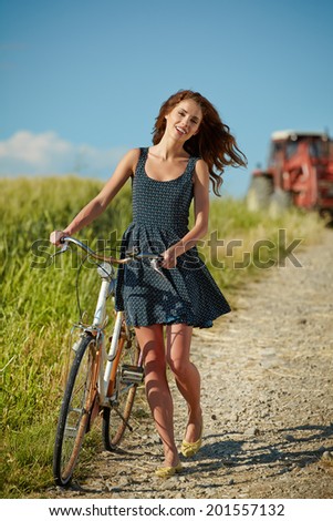 Woman riding bicycle in country field