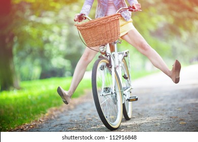 Woman riding bicycle with her legs in the air