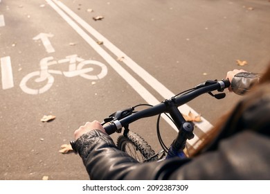 Woman riding bicycle on lane in city, closeup