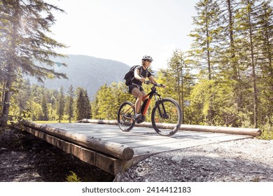 Woman riding e-mountain bike in the mountains - Powered by Shutterstock