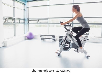 Woman Riding An Exercise Bike In Gym