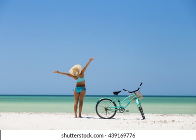 Woman Riding Her Bike Along The Beach In A Sunny Day