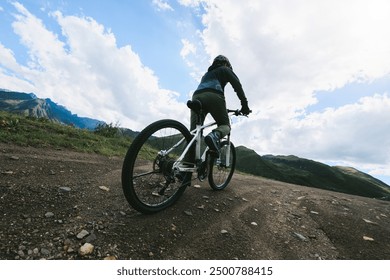 Woman riding mountain bike in the beautiful mountains - Powered by Shutterstock