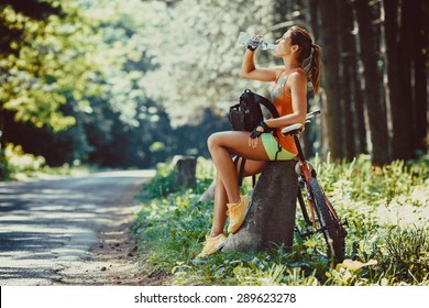 Woman riding a mountain bike in the forest.She  resting ,making pause. - Powered by Shutterstock