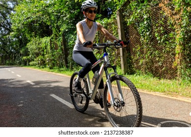 Woman riding on bike path at park on sunny day - Shutterstock ID 2137238387