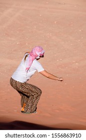 A Woman Riding A Sandboarding