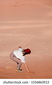 A Woman Riding A Sandboarding