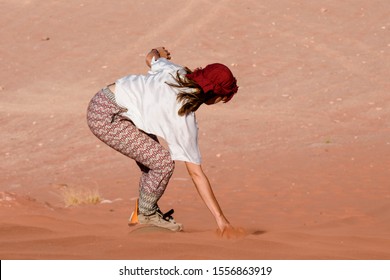 A Woman Riding A Sandboarding