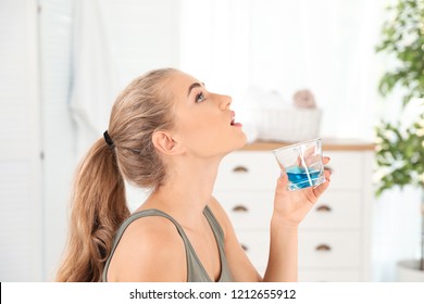 Woman Rinsing Mouth With Mouthwash In Bathroom. Teeth Care