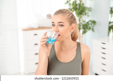 Woman Rinsing Mouth With Mouthwash In Bathroom. Teeth Care