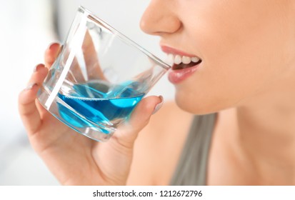 Woman Rinsing Mouth With Mouthwash In Bathroom, Closeup.Teeth Care