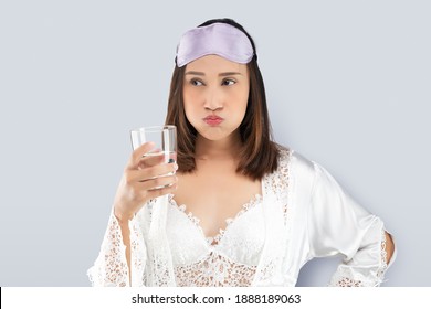 Woman Rinsing Your Mouth With Mouthwash After Brushing After Waking Up To Start Your Mornings. Dental Health Concepts. Female In White Silk Nightwear And Lace Robe Standing Gargle On A Gray Background