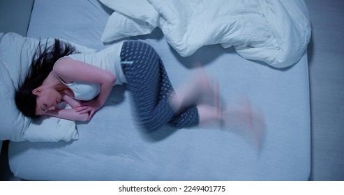 Mujer Con Síndrome De Piernas Inquietas. Dormir En La Cama