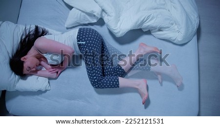 Woman With RLS - Restless Legs Syndrome. Sleeping In Bed