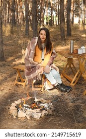 Woman Roasting Marshmallows On Fire In Autumn Forest