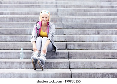 Woman With Roller Blades Sitting On Concrete Stairs