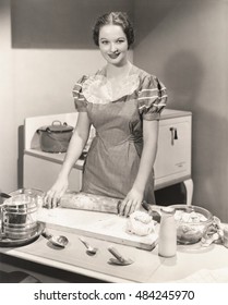 Woman rolling dough on kitchen counter
