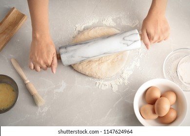 Woman rolling dough for pastry on table - Powered by Shutterstock