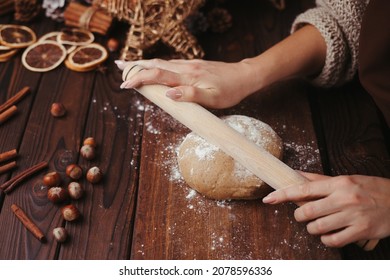 Woman rolling gingerbread dough with rolling pin