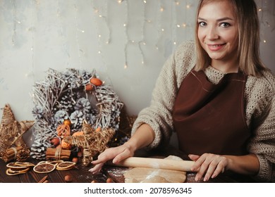 Woman rolling gingerbread dough with rolling pin