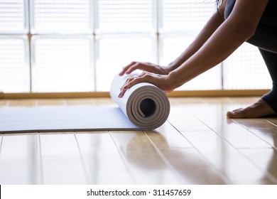 Woman Rolling Her Mat After A Yoga Class