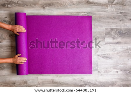 Woman rolling her Yoga mat after a workout - top view Foto d'archivio © 