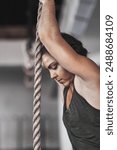 Woman, rope climbing and exercise in gym for health or cardio, fitness challenge with body strength. Female athlete, power workout and commitment to wellness or triathlon, sports club with training