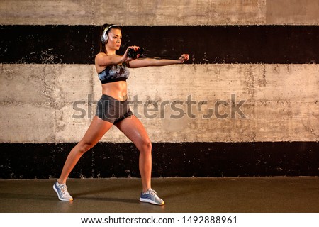 Similar – Image, Stock Photo One young athletic woman at crossfit training, exercising with trx suspension fitness straps over dark background, front view, looking at camera