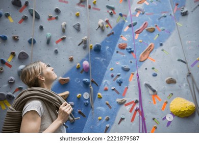 Woman with rope standing below rock climbing wall - Powered by Shutterstock