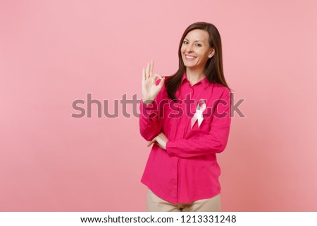Woman in rose clothes with pink silk ribbon symbol isolated on pastel wall background, studio portrait. Medical healthcare gynecological oncology, Breast Cancer Awareness concept. Mock up copy space