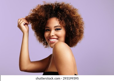 Woman With A Round Afro Hair Touching A Part Of It And Laughing