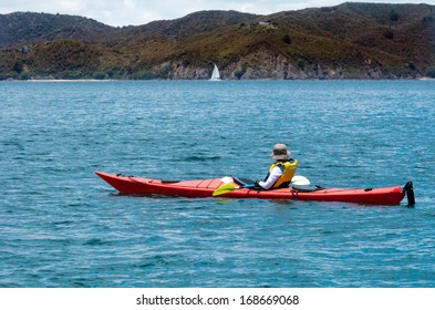 Woman Rows A Sea Kayak In The Bay Of Islands New Zealand. Very Popular Travel Destination Of NZ