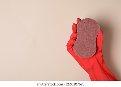 Woman in rubber glove holding sponge on beige background, top view. Space for text - Shutterstock ID 2160107693