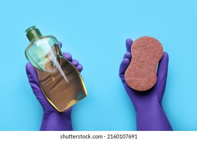 Woman in rubber gloves holding sponge and detergent on light blue background, top view - Shutterstock ID 2160107691