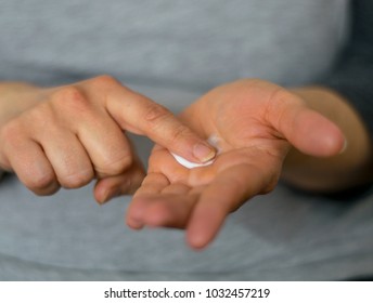 Woman Is Rubbing Cream In The Palm Of Her Hand